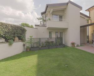 una casa blanca con un patio con césped verde en Villa Joy - Luxury chalet en Verona