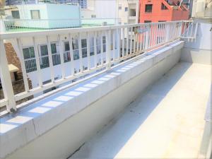 un balcón con una barandilla blanca en un edificio en Hotel Peace Park Tokaichi, en Hiroshima