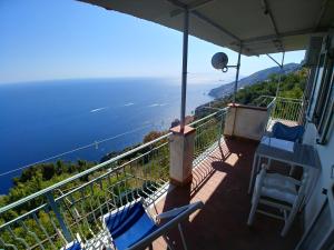 a balcony with chairs and a view of the ocean at GIARDINO SUL MARE in Amalfi