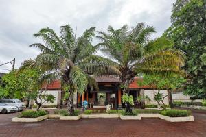 een gebouw met palmbomen ervoor bij Puri Saron Hotel Seminyak in Seminyak