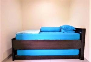 a bed with blue pillows on top of it at Giant Kost in Tangerang