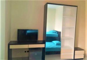 a mirror in a room with a bed and a television at Giant Kost in Tangerang