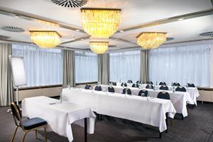 a conference room with white tables and chairs and chandeliers at Wyndham Stuttgart Airport Messe in Stuttgart