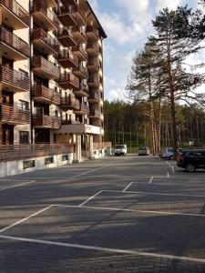 a parking lot with cars parked in front of a building at Apartman Relax Lux - Vila Peković in Zlatibor