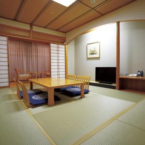 a room with a table and chairs and a tv at The Gran Resort Oumi Maiko in Otsu