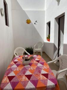 einen Esstisch mit einer bunten Decke darauf in der Unterkunft Apartamentos Gharb Diem in Tavira