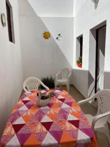 a dining room table with a colorful quilt on it at Apartamentos Gharb Diem in Tavira
