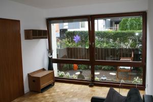 uma sala de estar com uma grande porta de vidro para um jardim em Enis Apartment - Biete wunderschönes möbliertes Zimmer an em Stuttgart