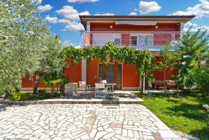 a red house with a patio in front of it at Apartment with nice terrace 684 in Štinjan