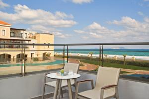 a balcony with a table and chairs and the ocean at Atlantica Caldera Palace in Hersonissos
