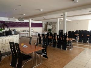 a restaurant with wooden tables and black chairs at okuninkapokoje in Okuninka