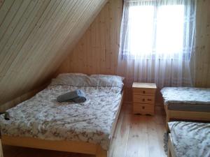 1 dormitorio con 2 camas individuales y ventana en Agroturystyka Uroki Roztocza, en Zamość