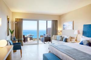 a hotel room with a bed and a view of the ocean at Daios Cove in Agios Nikolaos