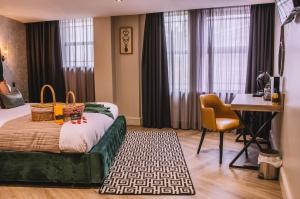 a hotel room with a bed and a table and a desk at The Grand Hotel in Swansea