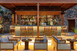 a restaurant with a bar with chairs and tables at Daios Cove in Agios Nikolaos