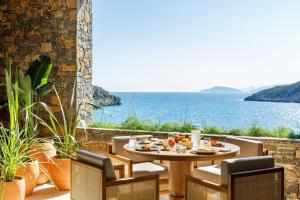 a table and chairs with a view of the ocean at Daios Cove in Agios Nikolaos