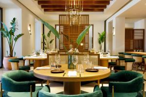 a restaurant with wooden tables and green chairs at Daios Cove in Agios Nikolaos