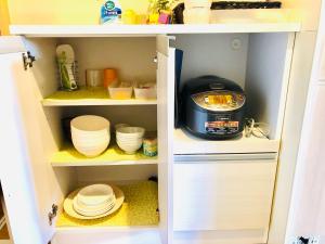 a kitchen pantry with plates and bowls and a mixer at Espoir Inn 1-201 in Kumamoto