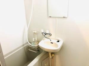 a small bathroom with a sink and a bath tub at Espoir Inn 1-201 in Kumamoto