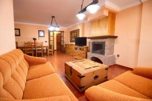 sala de estar con 2 sofás y chimenea en El Mirador de la Serrania, en Villalba de la Sierra