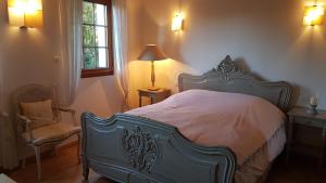 ベルフォールにあるDomaine de Chalétangのベッドルーム(ベッド1台、ランプ、椅子付)