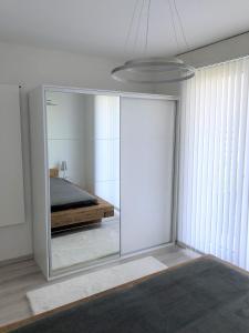 1 dormitorio con puerta de cristal y cama. en Les Dents-du-Midi, en Monthey