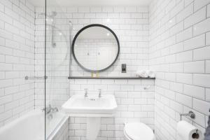 a white bathroom with a sink and a mirror at The Ballachulish Hotel in Glencoe