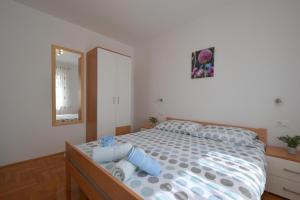 - une chambre avec un lit, une commode et un miroir dans l'établissement Apartment Baran, à Čižići