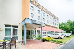 ein Hotel mit einem Tisch und Stühlen außerhalb in der Unterkunft ACHAT Hotel Chemnitz in Chemnitz