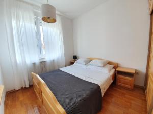 ein Schlafzimmer mit einem großen Bett und zwei Fenstern in der Unterkunft Galileo Apartment in Zagreb