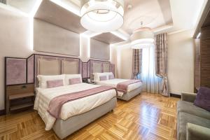 um quarto com 2 camas e um sofá em Solo Experience Hotel em Florença