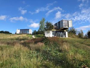 a house on top of a hill in a field at BERGHEIM Container Loft in Schöneck