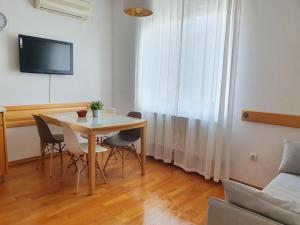 sala de estar con mesa, sillas y TV en Galileo Apartment, en Zagreb