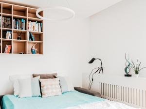 a bedroom with a bed and a book shelf at Oceana Silesian Place Apartments in Katowice
