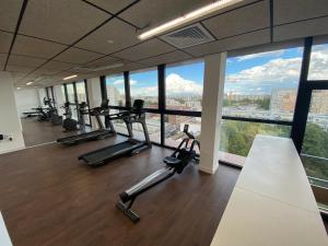 een fitnessruimte met loopbanden en crosstrainers in een gebouw met ramen bij Moov'Appart Hotel Clichy in Clichy