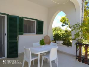 ein Esszimmer mit einem weißen Tisch und Stühlen sowie einem Fenster in der Unterkunft La prima casa in Polignano a Mare