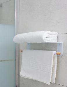 a towel rack with white towels on it in a bathroom at Hôtel Mac Bed in Poitiers