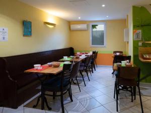 a dining room with long tables and chairs at Hôtel Mac Bed in Poitiers