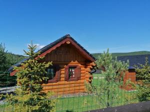 a log cabin with a fence in front of it at Camp PACHO in Prievidza