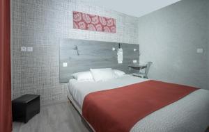 Un dormitorio con una cama grande con una manta roja. en Hôtel Mac Bed, en Poitiers