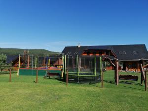 a playground in a grassy field next to a building at Camp PACHO in Prievidza