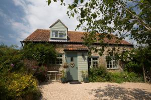 a small brick house with a green door at Chiddy Nook Cottage in Chideock