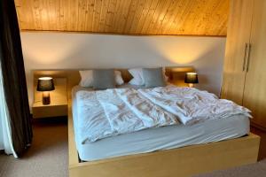 a bedroom with a large white bed with two lamps at Ferienhaus mit Bootssteg am See in Rheinsberg in Rheinsberg