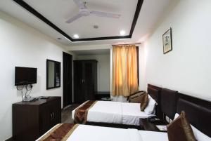 a hotel room with two beds and a flat screen tv at HOTEL VEER PALACE in New Delhi