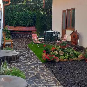 a patio with two chairs and a table and flowers at KOMFORT in Berehove