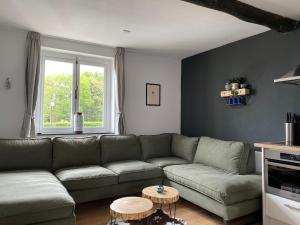 sala de estar con sofá verde y mesa en Authentic Stays - 6p-apartment, en Eijsden