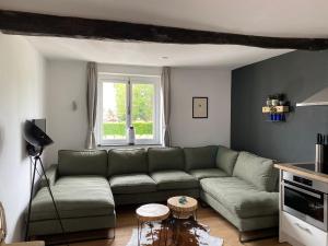ein Wohnzimmer mit einem grünen Sofa und einem Tisch in der Unterkunft Authentic Stays - 6p-apartment in Eijsden