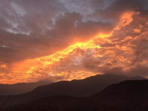 una puesta de sol sobre las montañas con nubes en el cielo en Bliss Bed and Breakfast en Yuchi