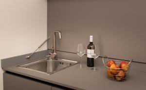 a counter top with a bottle of wine and a knife at Iancu Charme Apartments in Taormina