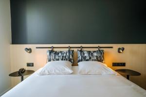 a bedroom with a large bed with two pillows at Live Hotels Bordeaux Lac in Bordeaux